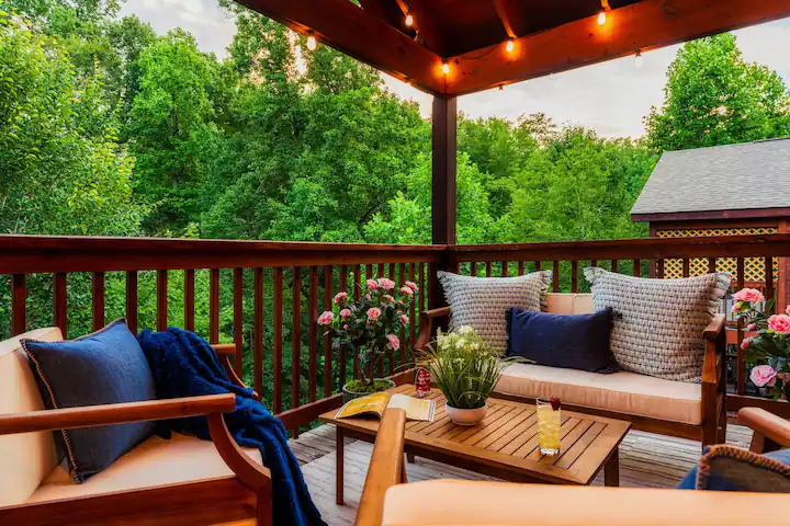 Lounge deck with string lights and wooded views